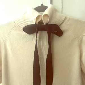 Cream short sleeve sweater with front navy bow.